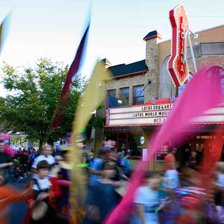 People walk in the street at the Lotus World Music and Arts Festival, in front of Buskirk-Chumley Theater
