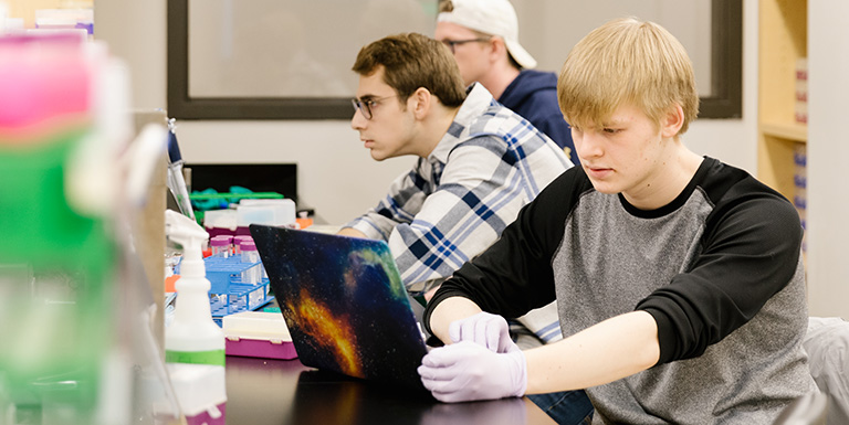 Three students working in a science lab 