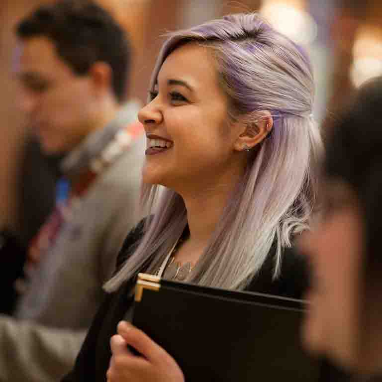 A smiling student with purple hair.