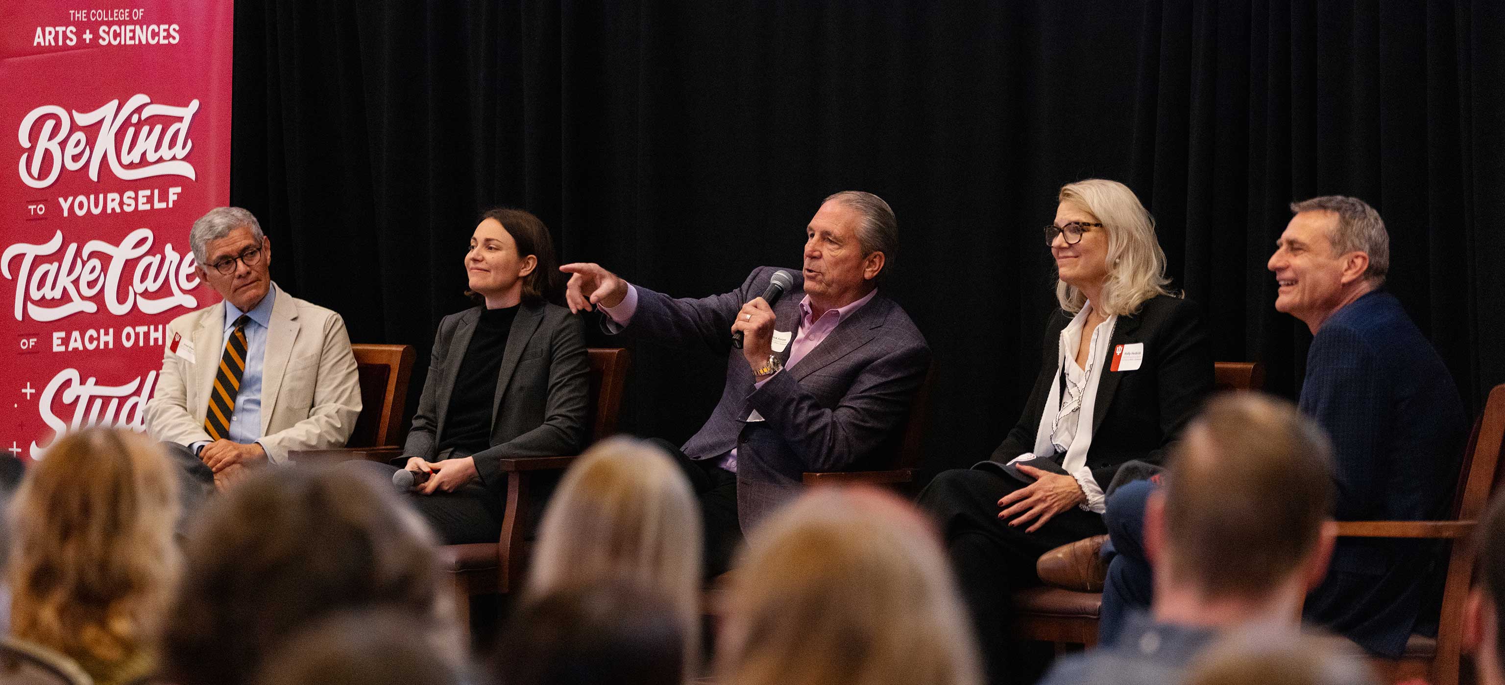 The 2023 alumni award recipients and executive dean Rick Van Kooten talk on stage during a panel discussion in the Indiana Memorial Union's Alumni Hall.