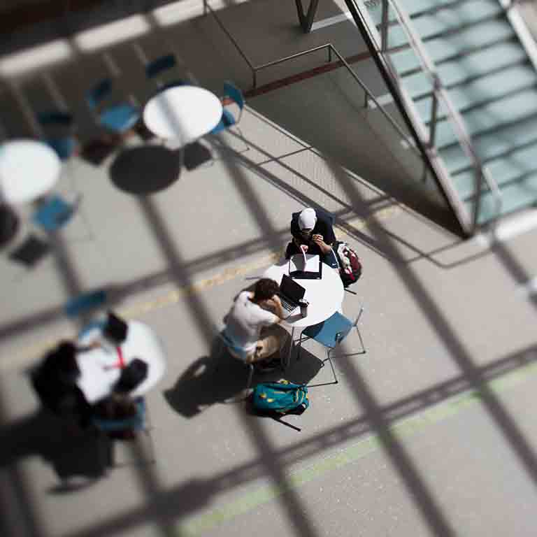 Students sit around a table in the Global and International Studies Building.