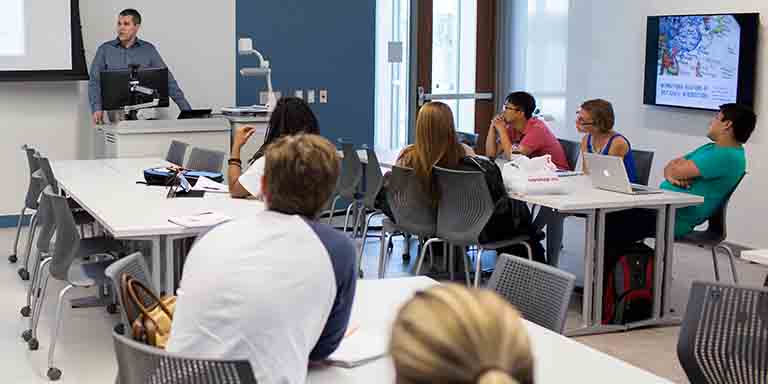A class meets in a modern classroom in the Global and International Studies Building.